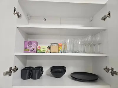 a kitchen shelf with glasses and other items on it at Centre NEW stylish apartment & parking near O2 Arena in Prague