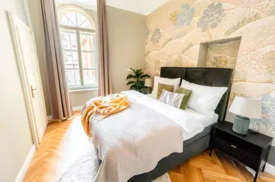 a bedroom with a large bed with a floral wall at read host profile # 5BR SOHO Suites Old Town PS5 Billiards B205 in Prague
