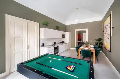 a living room with a pool table and a kitchen at read host profile # 5BR SOHO Suites Old Town PS5 Billiards B205 in Prague