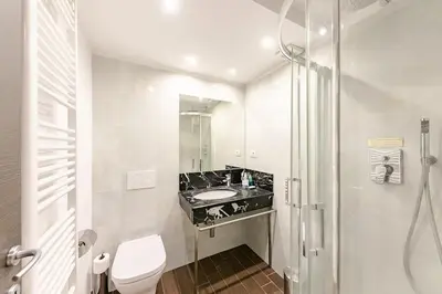 a bathroom with a sink and a toilet and a mirror at Maisonette General Stefanik in Prague