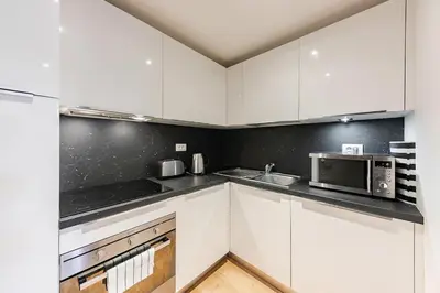 a kitchen with white cabinets and a microwave at Maisonette General Stefanik in Prague