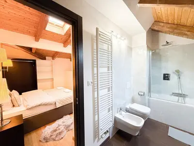 a bathroom with a bed and a toilet and a sink at Maisonette General Stefanik in Prague