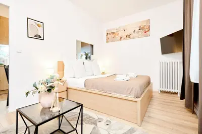 a bedroom with a bed with a vase of flowers at Casa Center Apartments in Prague