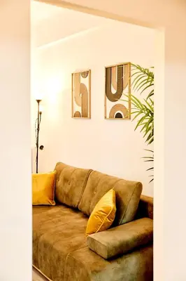a couch in a living room with two pictures on the wall at Casa Center Apartments in Prague