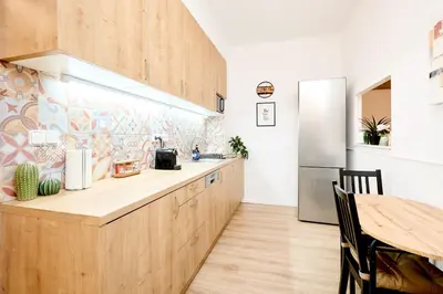a kitchen with wooden cabinets and a refrigerator at Casa Center Apartments in Prague