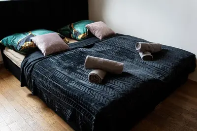 a black bed with pillows and towels on it at Golden Aurora Prague in Prague