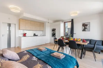 a kitchen with white cabinets and a table with chairs at Sunset Terrace Residence in Prague