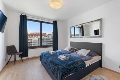 a bedroom with a bed and a large window at Sunset Terrace Residence in Prague