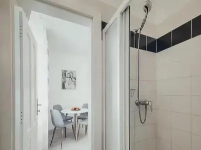 a bathroom with a shower and a table and chairs at Magical Prague Old Town in Prague
