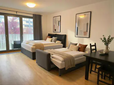 a hotel room with two beds and a table and a desk at Fortuna Garden V in Prague