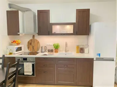 a kitchen with brown cabinets and a white counter top at Fortuna Garden V in Prague