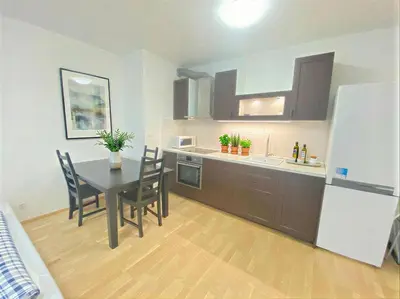 a kitchen with a table and chairs and a refrigerator at Fortuna Garden V in Prague