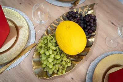 a plate of grapes and a melon on a table at Lion Prestige Residence in Prague