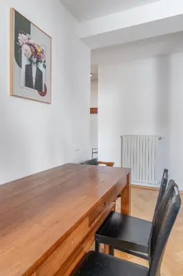 a wooden table with two chairs and a picture on the wall at Grand Gallery Riverside in Prague