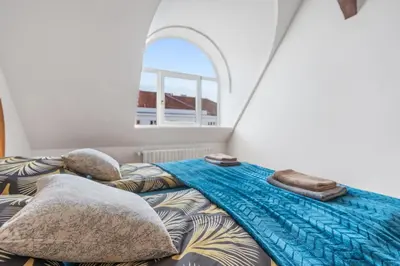 a bedroom with a bed with pillows and a window at Grand Gallery Riverside in Prague