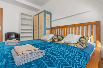 a bedroom with a blue bed with towels on it at Grand Gallery Riverside in Prague