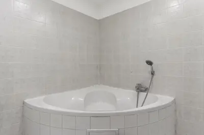 a white tub in a bathroom with a shower at Grand Gallery Riverside in Prague