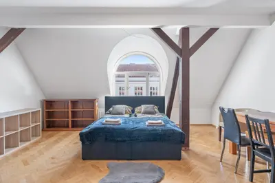 a bedroom with a bed and a large window at Grand Gallery Riverside in Prague