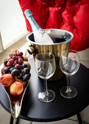 a table with two wine glasses and a bowl of grapes at Bohemian Luxe Central in Prague
