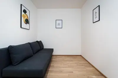 a couch in a living room with white walls at Bohemian Luxe Central in Prague