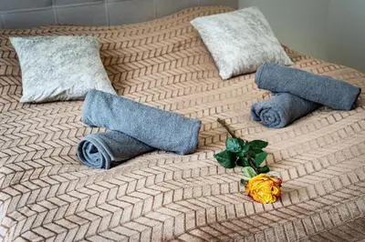 a bed with towels and flowers on top of it at Bohemian Luxe Central in Prague