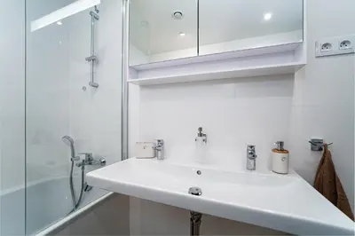 a white bathroom with a sink and a shower at Big Central Living in Prague