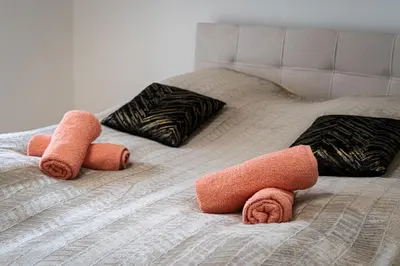 a bed with three towels on top of it at Big Central Living in Prague