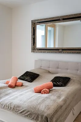 a bedroom with a bed with two pillows and a mirror at Big Central Living in Prague