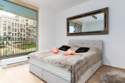 a bedroom with a bed with a mirror on the wall at Big Central Living in Prague