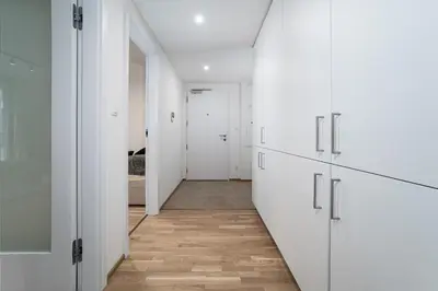 a hallway with white cabinets and a hallway with a bedroom at Big Central Living in Prague