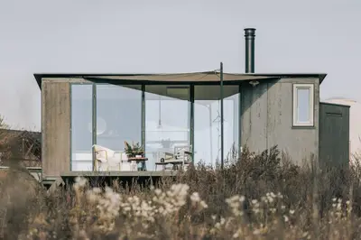 a small house with glass doors and a table and chairs at TINY HOUSE na Řehenickém Dvorku in Řehenice