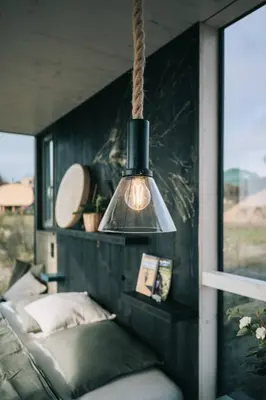 a pendant light hanging over a couch in a room at TINY HOUSE na Řehenickém Dvorku in Řehenice