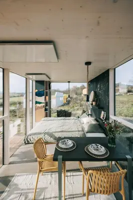 a bedroom with a bed and a table and chairs at TINY HOUSE na Řehenickém Dvorku in Řehenice
