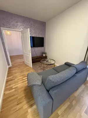 a living room with a blue couch and a flat screen tv at Apartment with garage for 4 people in Prague