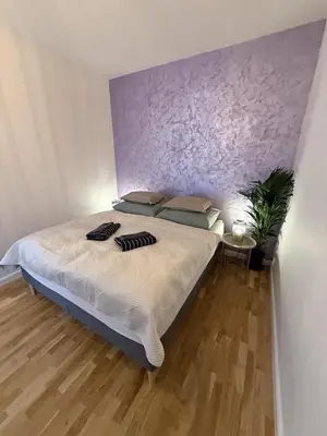 a bedroom with a large bed with a purple wall at Apartment with garage for 4 people in Prague