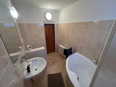 a bathroom with a white tub and a sink at Prague apartment - Close to airport and metro in Prague