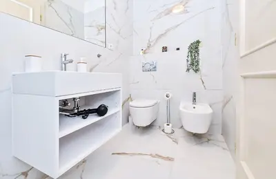 a white bathroom with a sink and a toilet at Kora Premiere Collection in Prague
