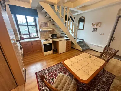 a living room with a table and a staircase at Apartmány v Buši in Buš