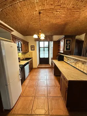 a kitchen with a white refrigerator and a tile floor at Apartmány v Buši in Buš