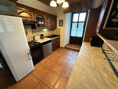 a kitchen with a white refrigerator and a tile floor at Apartmány v Buši in Buš