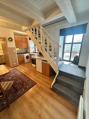 a living room with a staircase and a kitchen at Apartmány v Buši in Buš