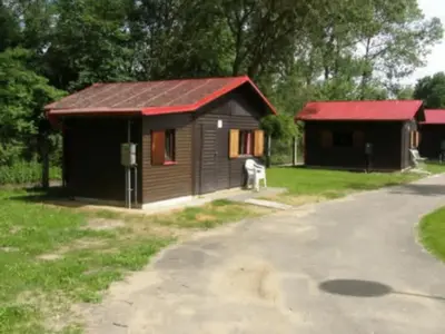 a small cabin with a red roof next to a road at Autocamp Kosmonosy in Mladá Boleslav