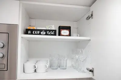 a cupboard with glasses and a sign on it at Prague Muzeum Apt - 2 min to Wenceslas Sq, Praha 1 in Prague