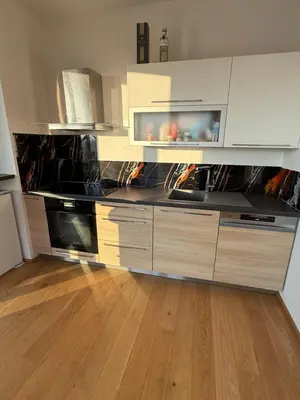 a kitchen with a large counter top with wooden floors at Luxury 3-room apartment with swimming pool - Modřany in Prague