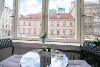 a table in front of a window with a view of a building at Cozy Apartment in the heart of Prague in Prague