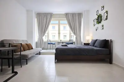 a bedroom with a bed and a living room at Cozy Apartment in the heart of Prague in Prague