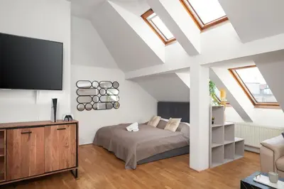 a bedroom with a bed and a flat screen tv at Sky Loft near Center 220m, AC, PS5, Free Parking in Prague