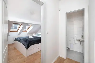 a white bedroom with a bed and a bathroom at Sky Loft near Center 220m, AC, PS5, Free Parking in Prague