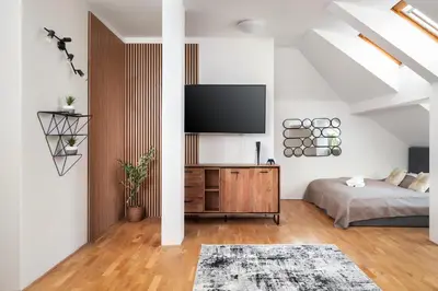 a bedroom with a bed and a flat screen tv at Sky Loft near Center 220m, AC, PS5, Free Parking in Prague