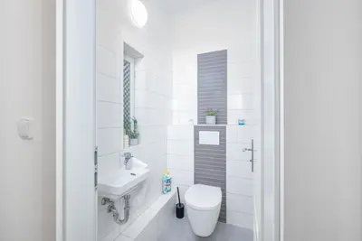 a white bathroom with a toilet and a sink at Sky Loft near Center 220m, AC, PS5, Free Parking in Prague